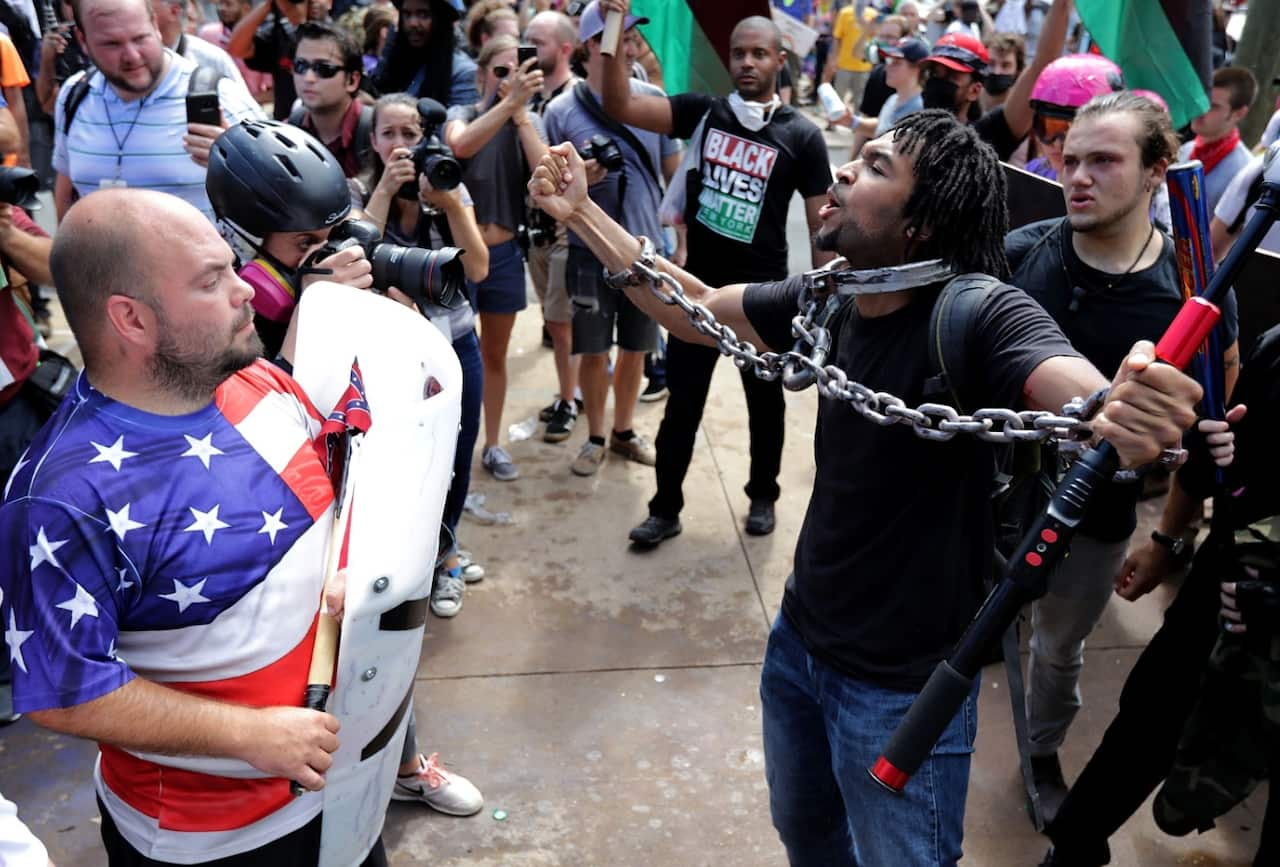White nationalists, neo-Nazis and members of the 'alt-right' exchange insults with counter-protesters as they attempt to guard the entrance to Lee Park