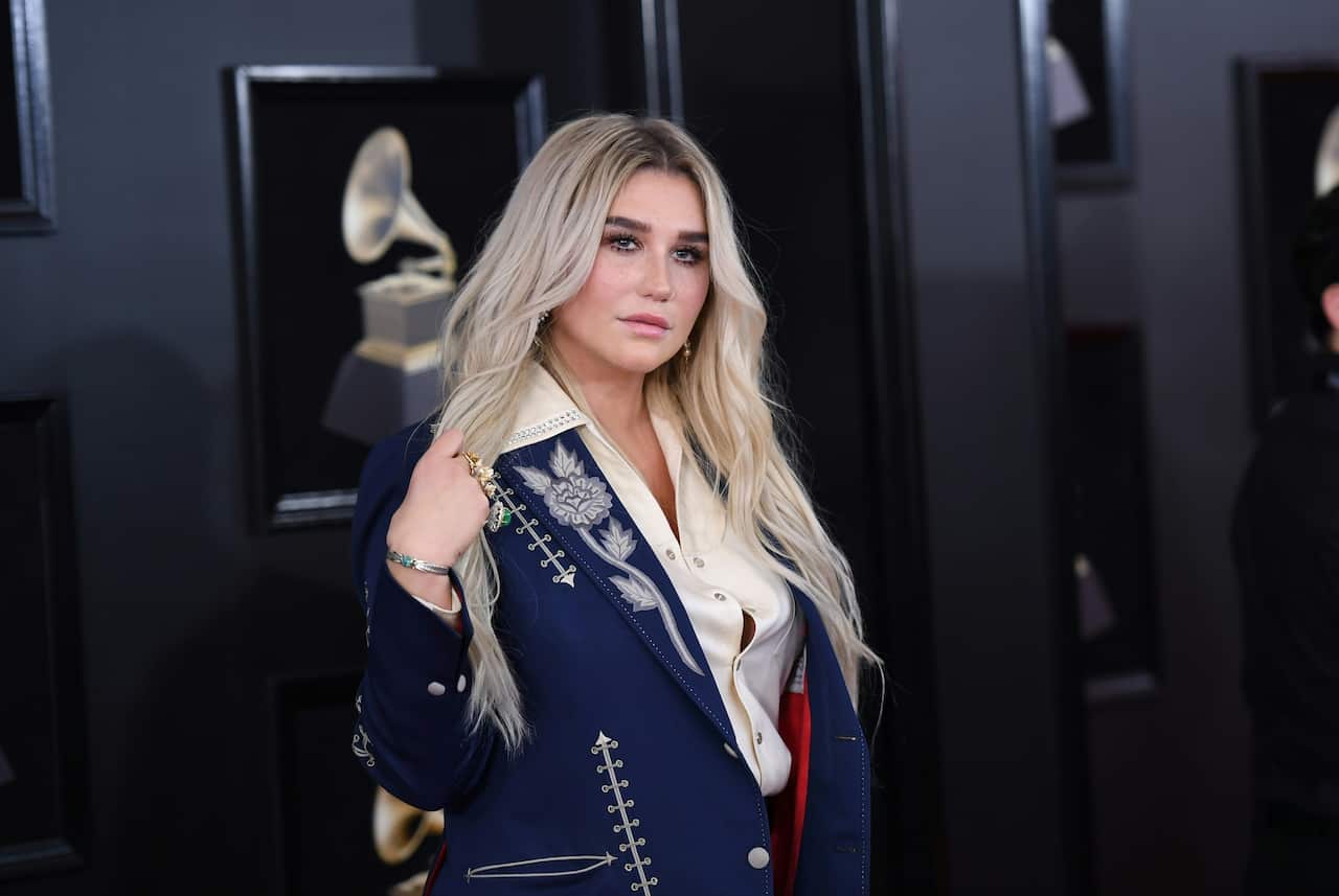 Kesha wears a embroidered white rose on her tuxedo jacket at the 60th Annual Grammy Awards, 2018.