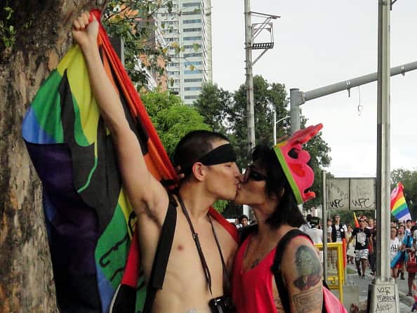 A Filipino gay couple kiss for a photo during the annual...
