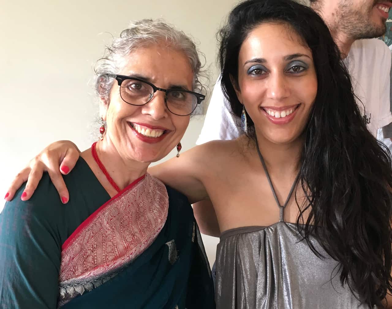 South Asian older woman and daughter smiling at camera