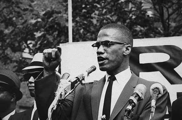 1963:  American civil rights leader Malcolm X (1925 - 1965)  at an outdoor rally, probably in New York City.  