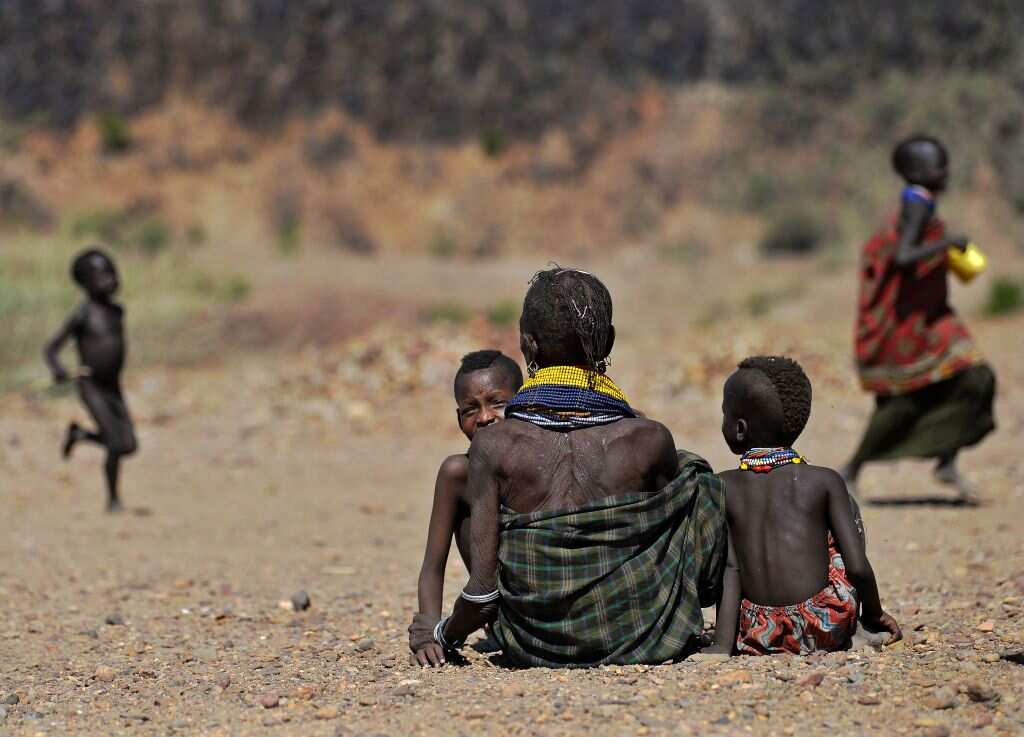 A woman waits with her children to get food rations near Lokitaung in northern Kenya's Turkana county where a biting drought has ravaged livestock population.