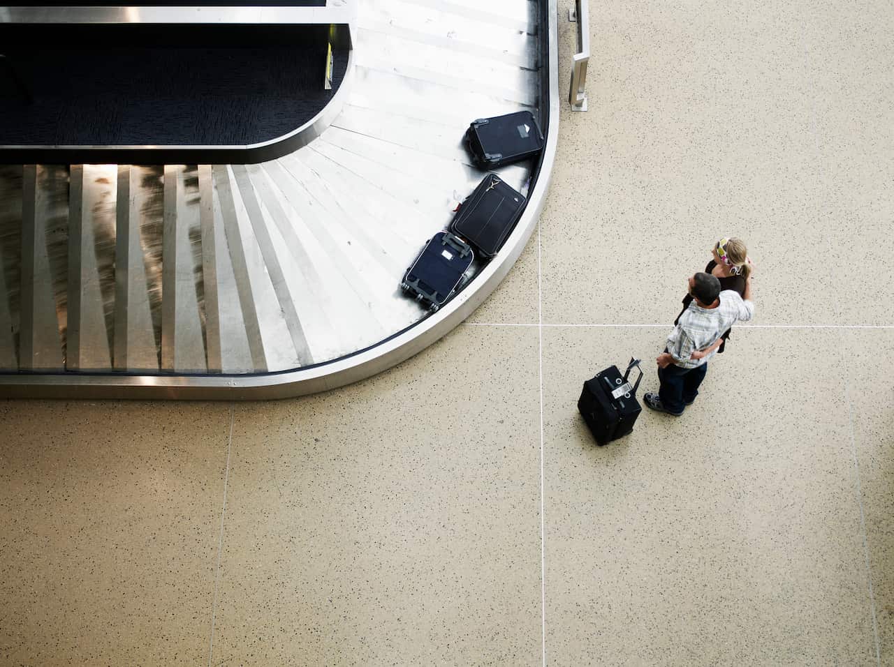 Couple waiting for luggage at baggage claim 