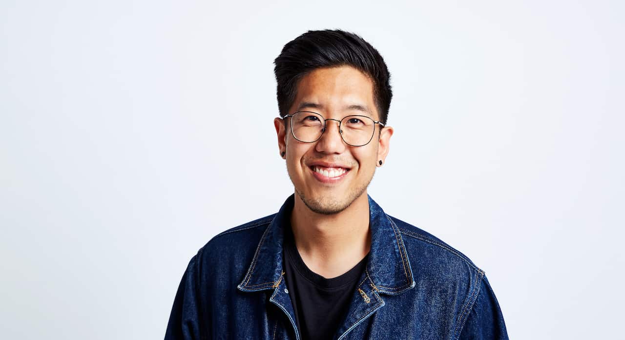 Asian man smiling at camera.