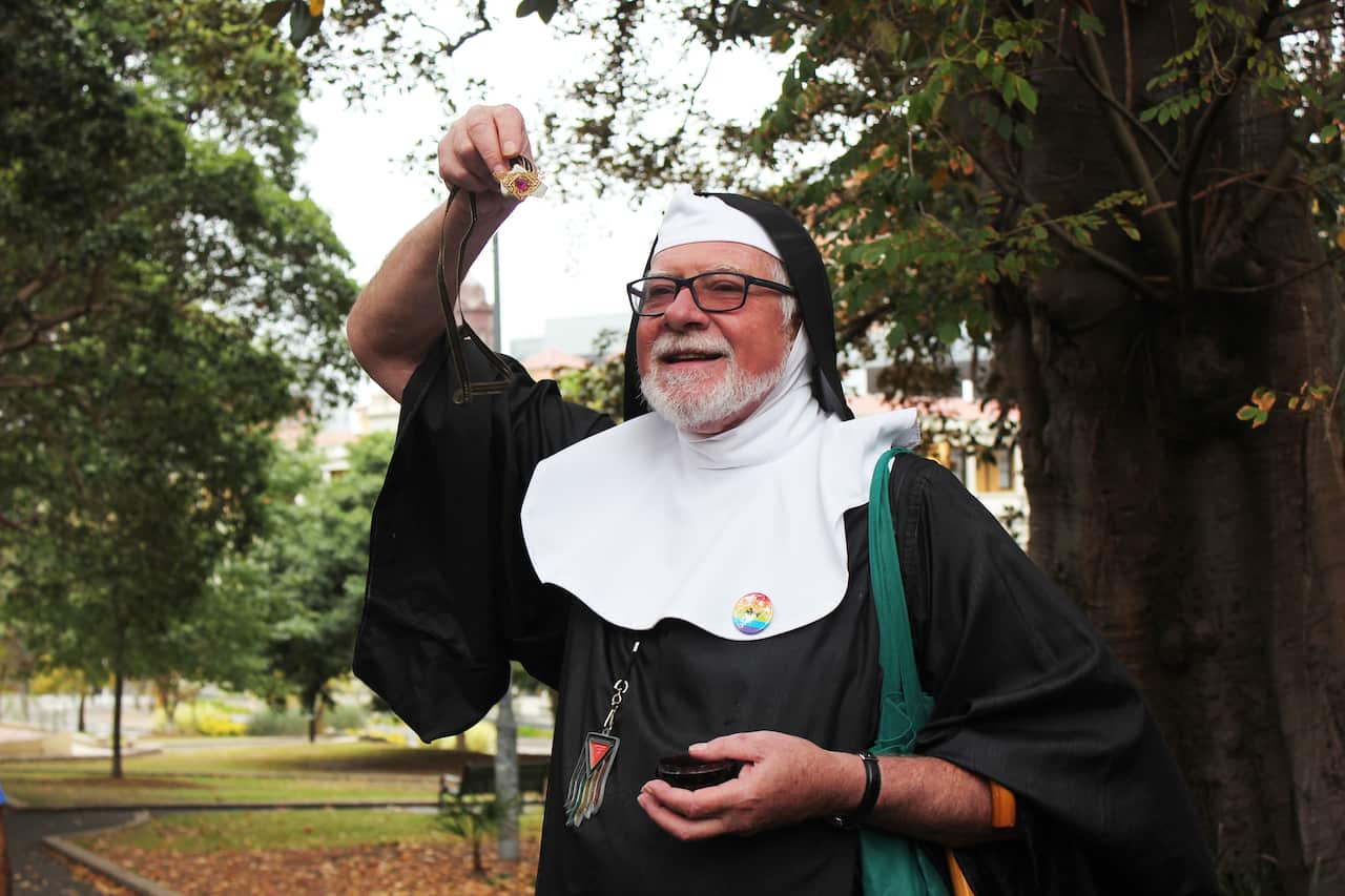Sister Salomé of the 9th Mystic Rhinestone showing the crowd a precious relic - a tile that was once part of the urinal at the Green Park beat.