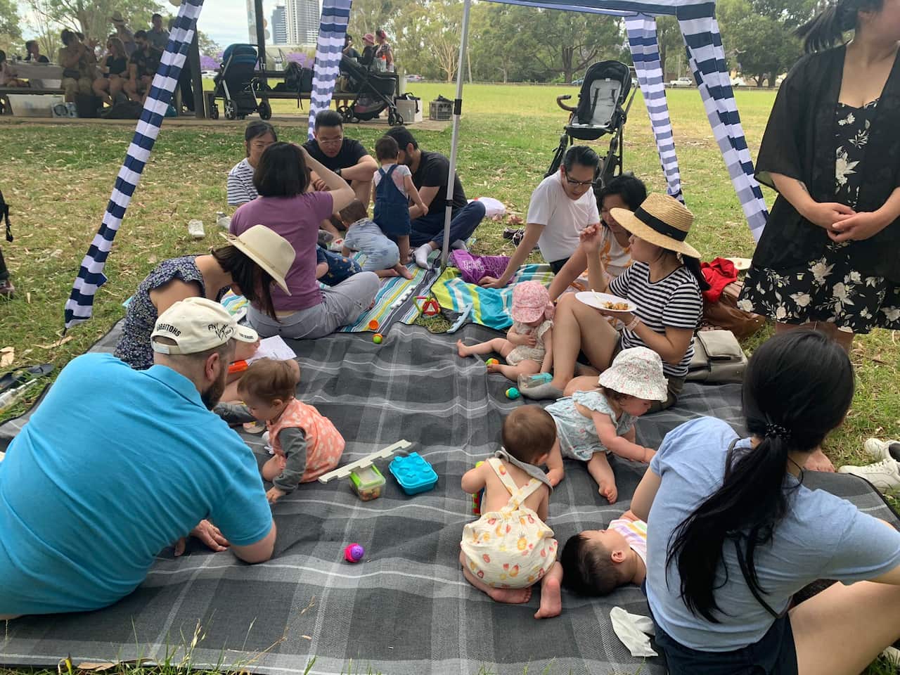 Mums, dads and babies having a picnic in the park.
