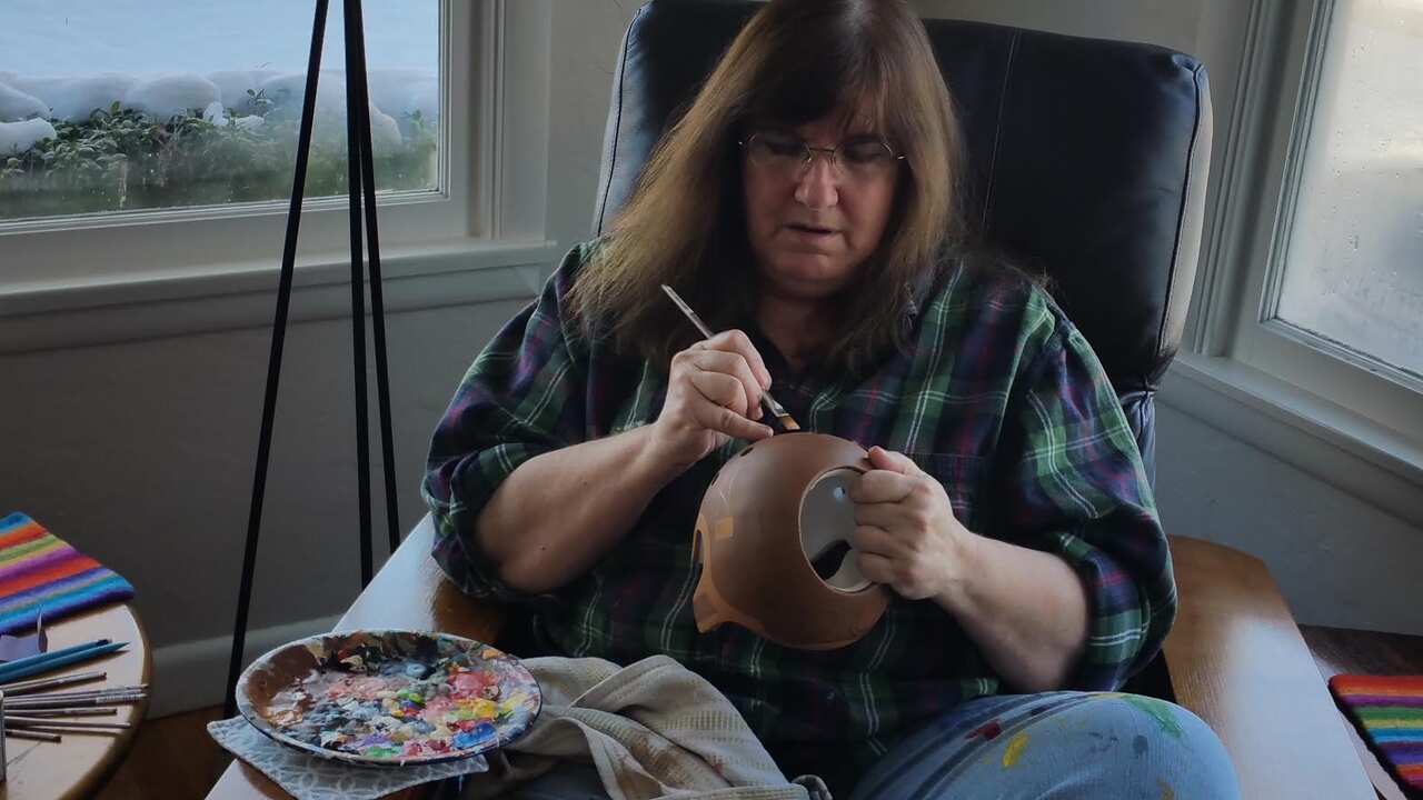 Artist Paula Strawn painting a baby helmet