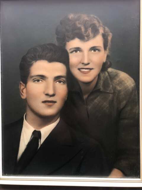 Miranda's parents in their wedding photo. Her mother is standing next to her father, their faces close together. 