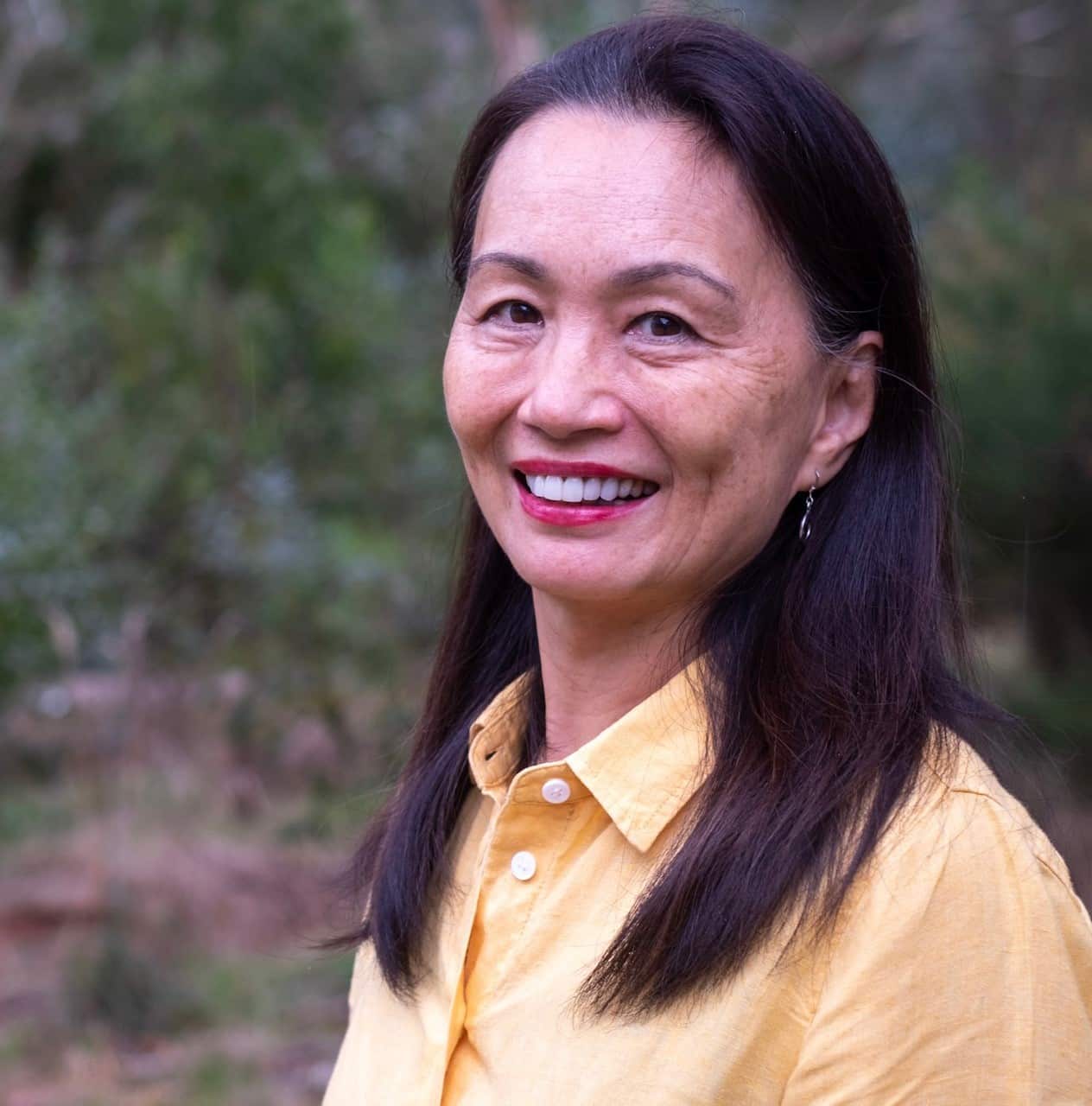 Photo of Asian woman in her 60s in yellow shirt