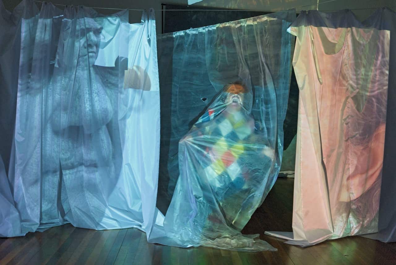 Debra Keenahan on stage with images projected onto curtains