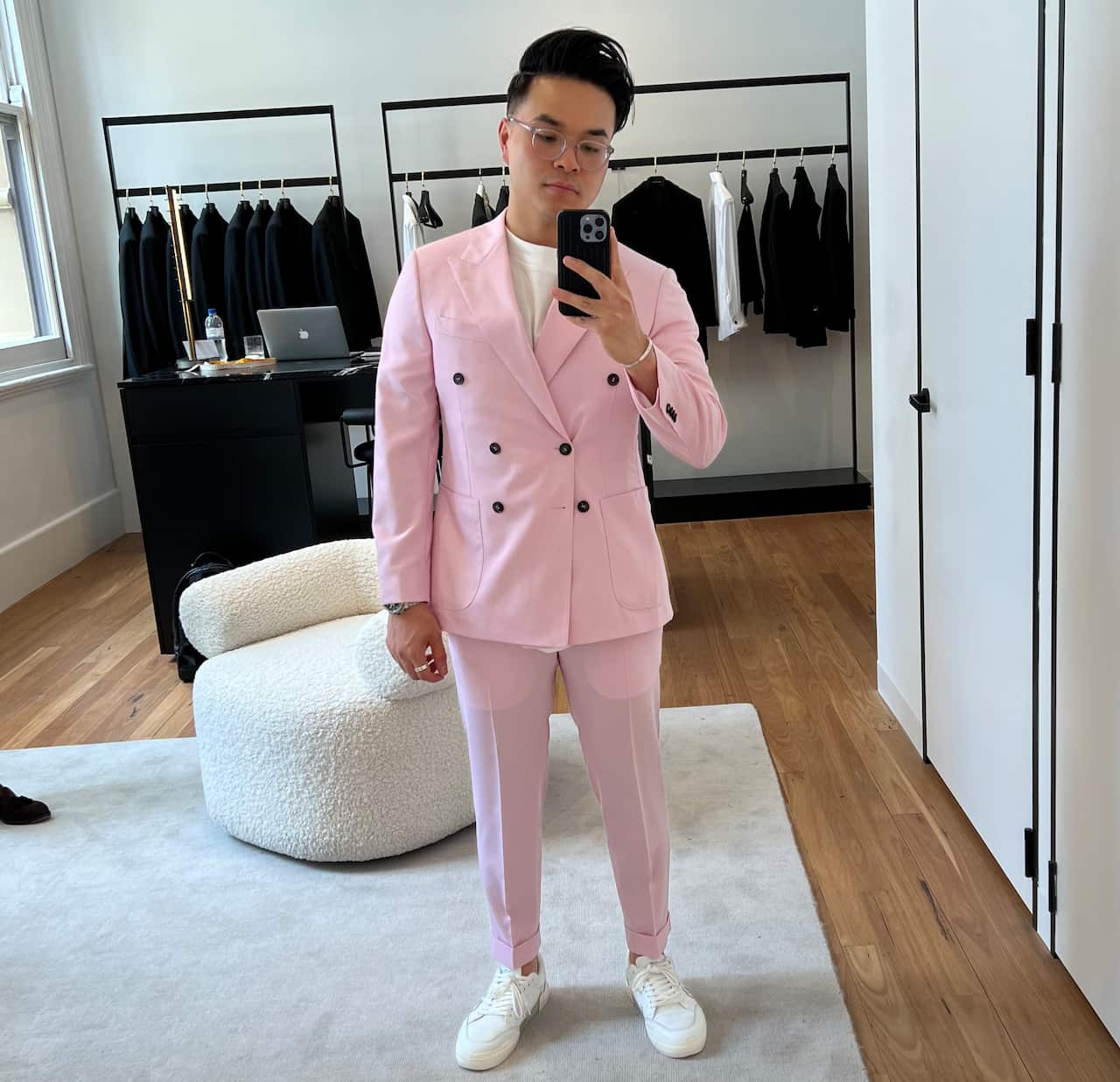 Young Asian man in pink suit, taking photo of himself in the mirror.
