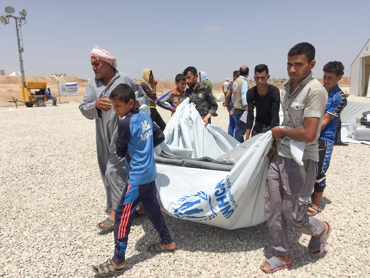 Families fleeing militant extremist groups and heavy bombing in western Mosul collect their tents and emergency kits upon arrival at Hasansham U2 camp. 