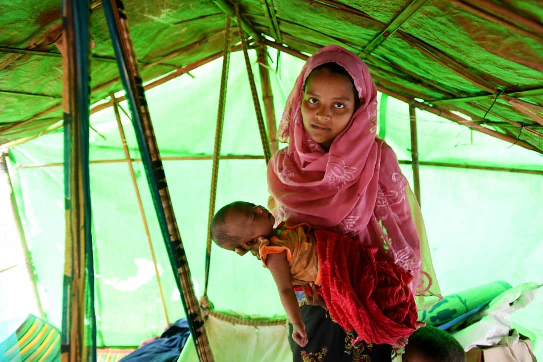 Rohingya refugee Janet Ara with her 27-day-old baby boy Mohammad Arshat in a cradle swing made from a rice sack at the Balukhali refugee camp on December 12.