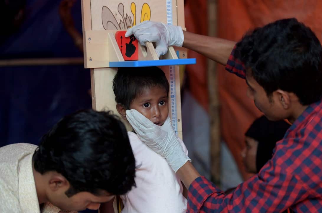 A nurse runs a health check on a malnourished Rohingya child at a health centre run by Save the Children at the Balukhali refugee camp.