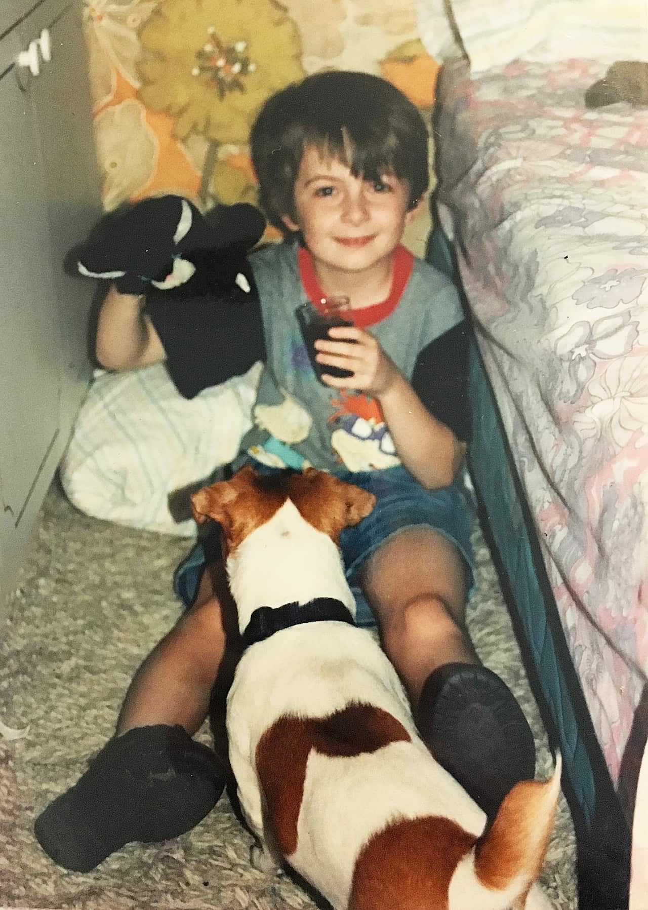 Young boy on floor with Jack Russell dog.