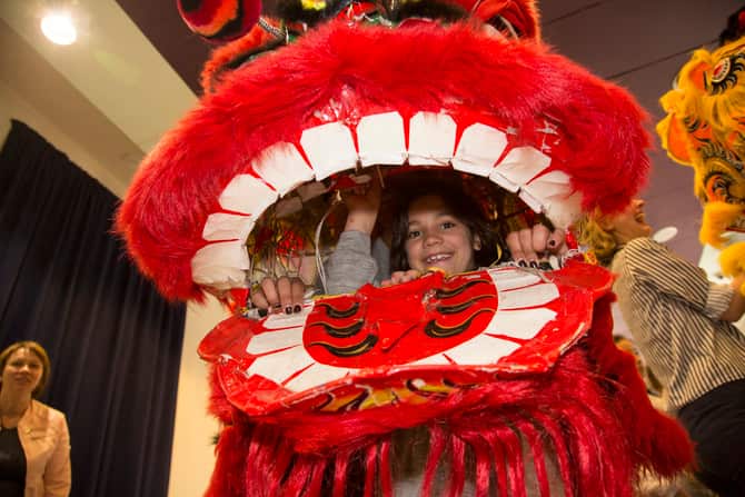 Scarlet and Laura wearing the Chinese Lion Head at the Lion Dance Workshop run by the Jow Ga Kuen Dragon & Lion Dance Association, during the Spring school holiday program at the Immigration Museum. 