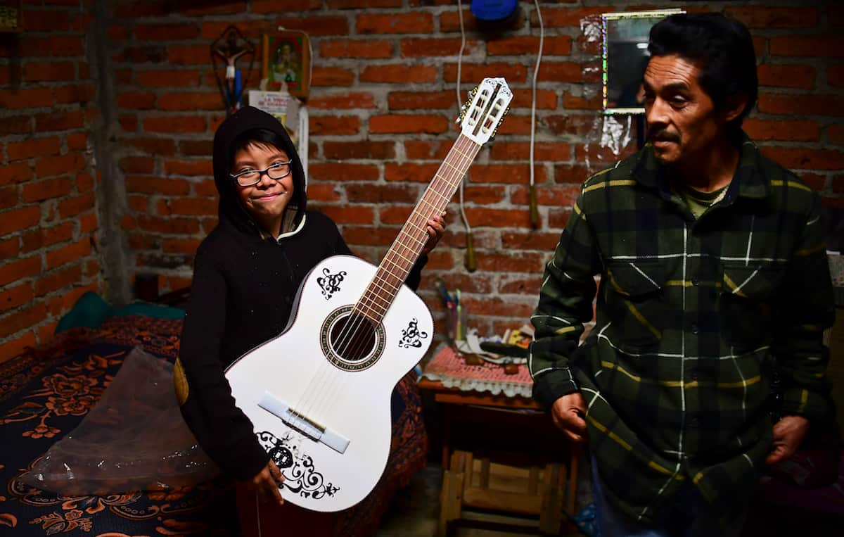 Mexican child Angel Figueroa, 10, smiles after receiving a replica guitar from "Coco". 