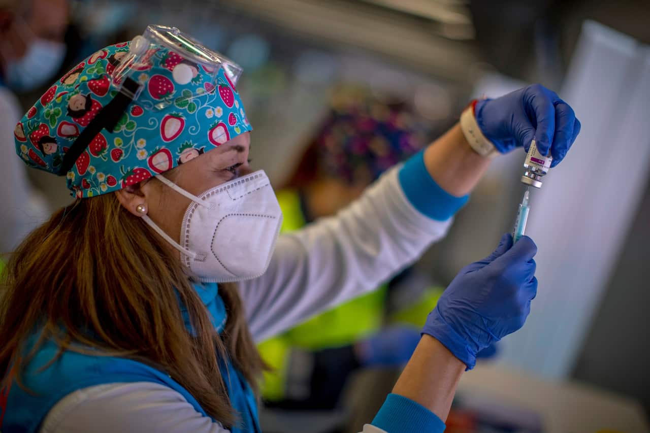 A file photo of a health worker holding a vial of AstraZeneca vaccine.