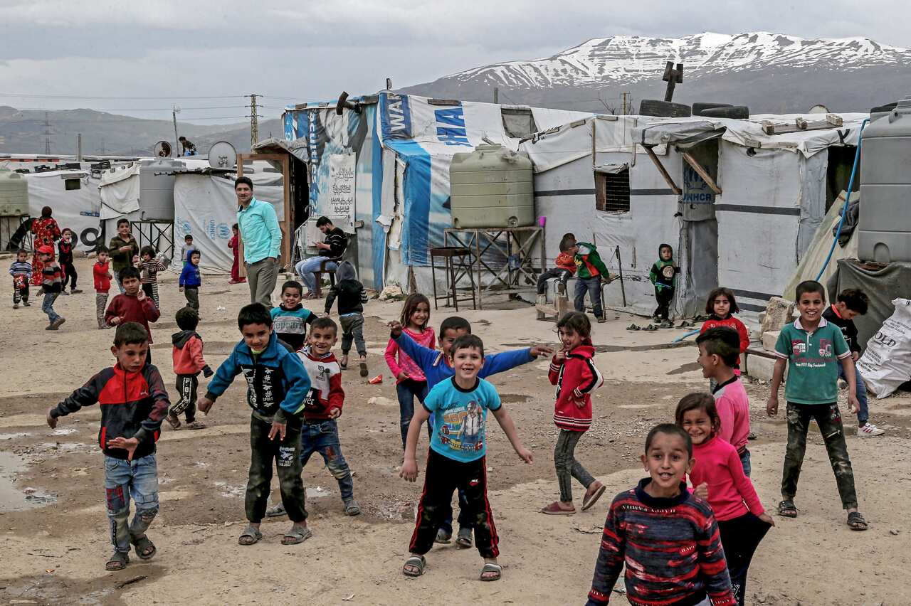 Syrian refugee children in front of makeshift tents at Al Faydah refugee camps in Lebanon.