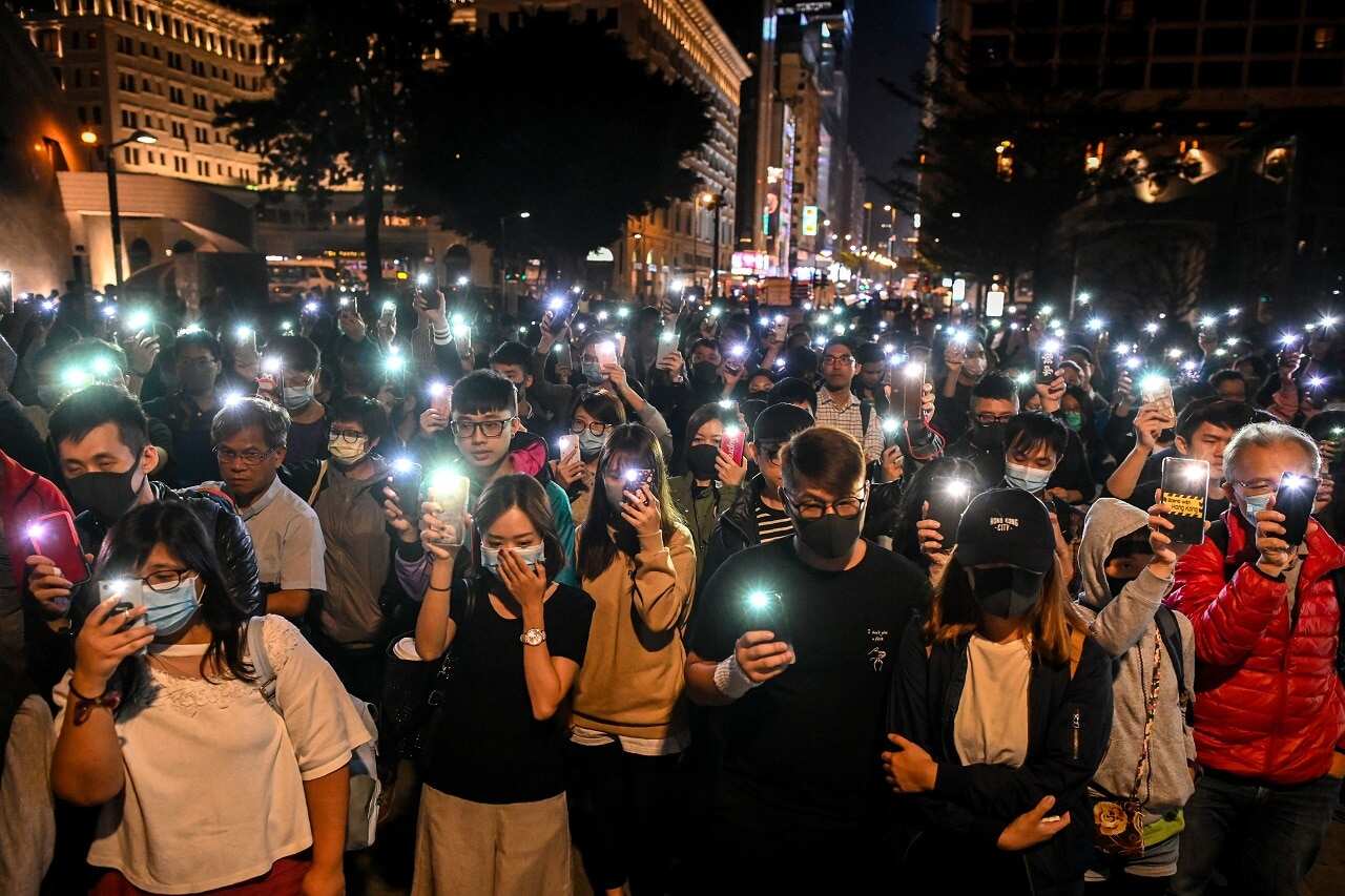 People hold their mobile phones as they gather to pray for the students who are barricaded inside Hong Kong Polytechnic University.