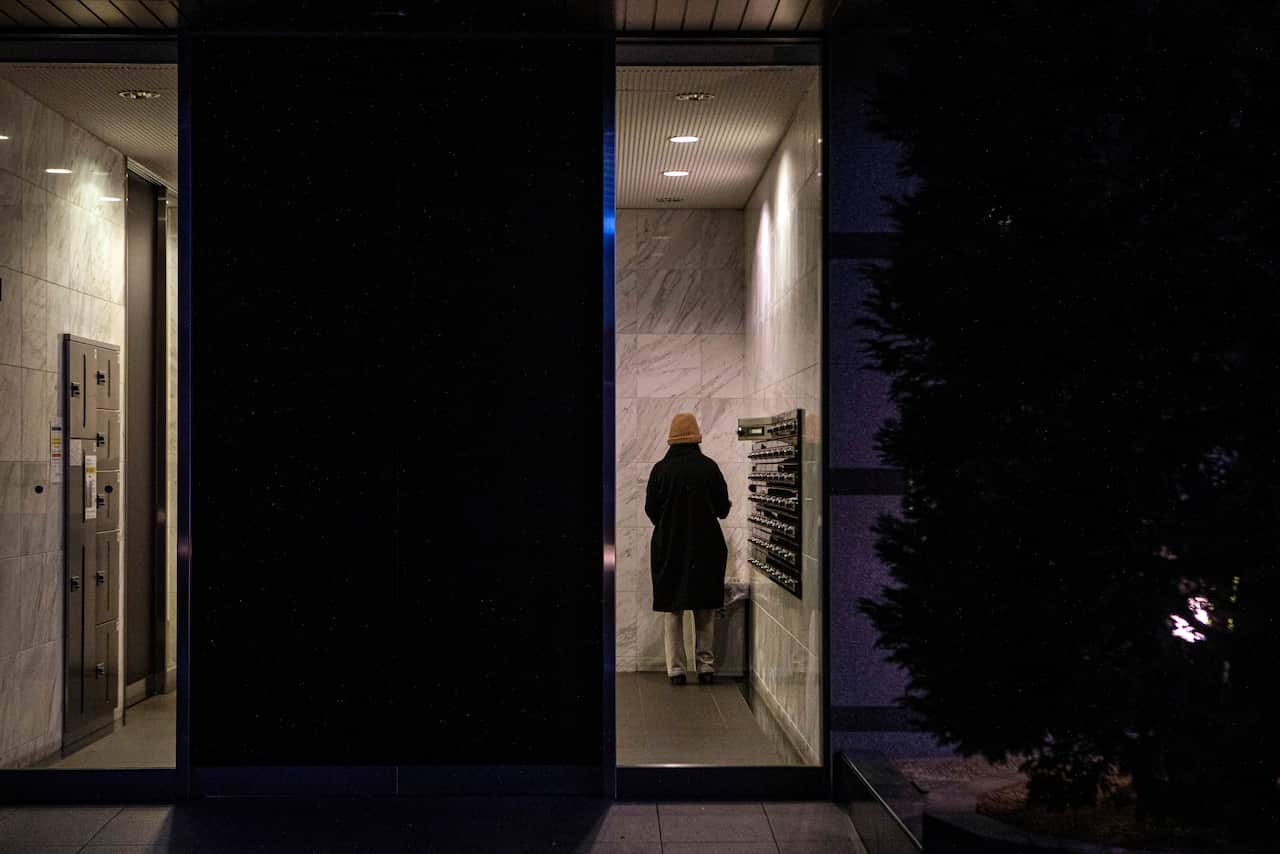 A woman retrieves mail in the lobby of an apartment building in Osaka, Japan, on 20 February, 2021.