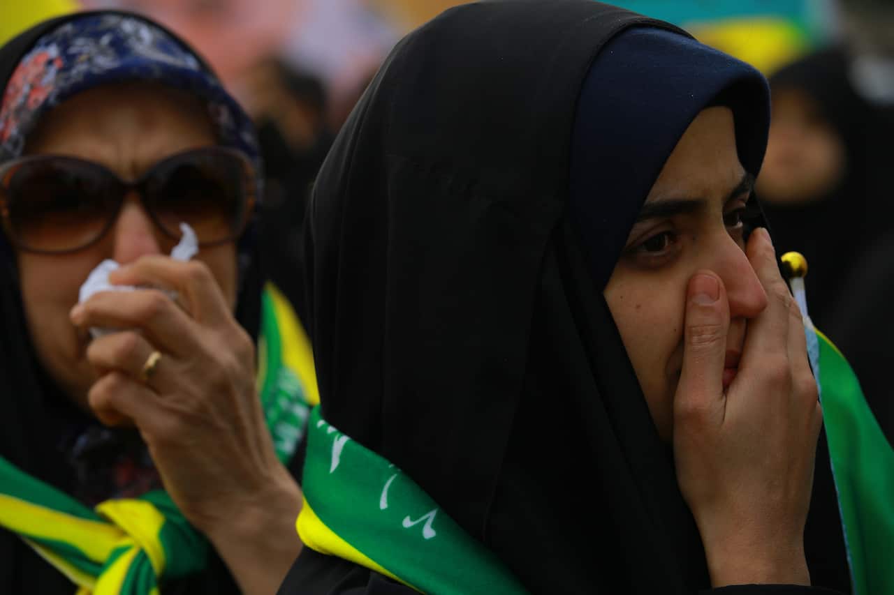 Mourners react as they attend a funeral procession for Qassem Soleimani.