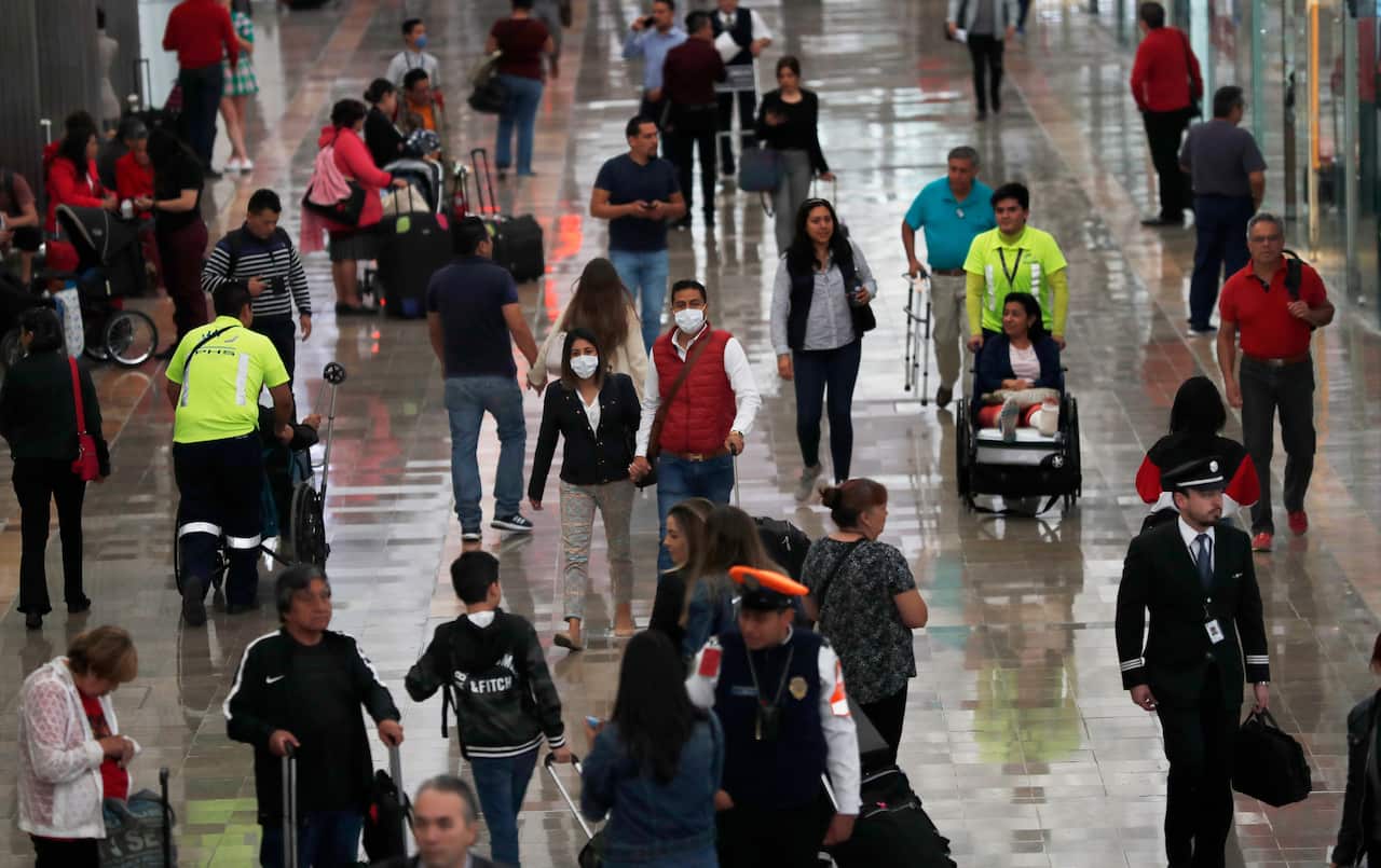 A couple wears protective masks as a precaution against the spread of coronavirus at the airport in Mexico City.