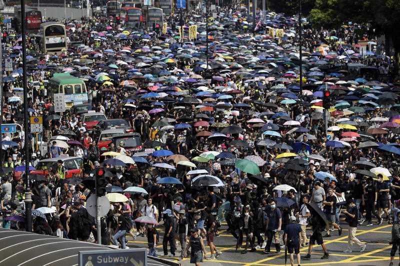 Protesters carrying umbrellas march on a street in Hong Kong