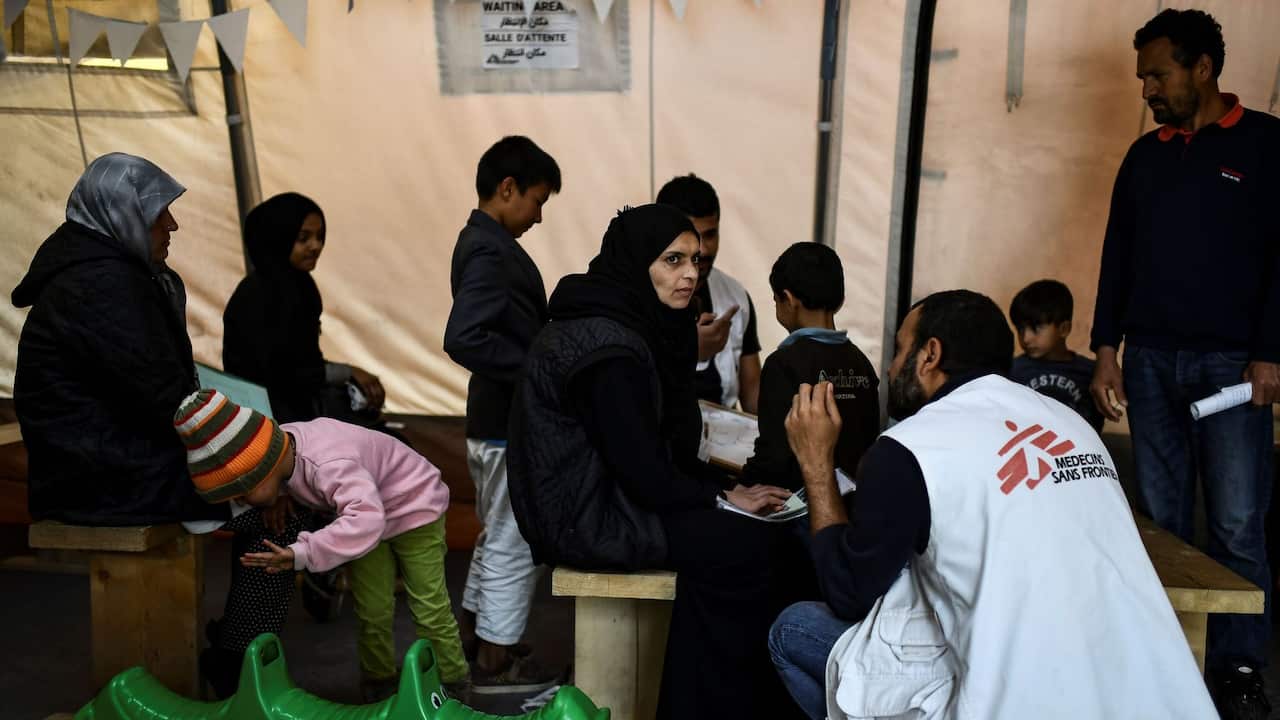 People wait to receive treatment at the Doctors Without Borders (MSF) clinic outside the refugee camp of Moria, on the Greek island of Lesbos, on March 19, 2019. - When thousands of people fleeing war and poverty began arriving on their Greek island, many