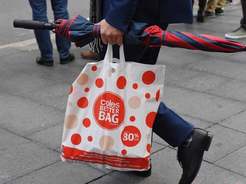 A shopper is seen carrying a reusable plastic bag from Coles.