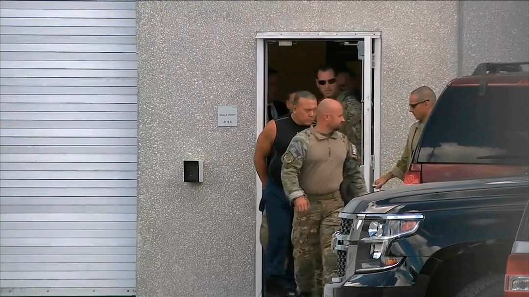 FBI agents arrest Cesar Sayoc, in sleeveless shirt.