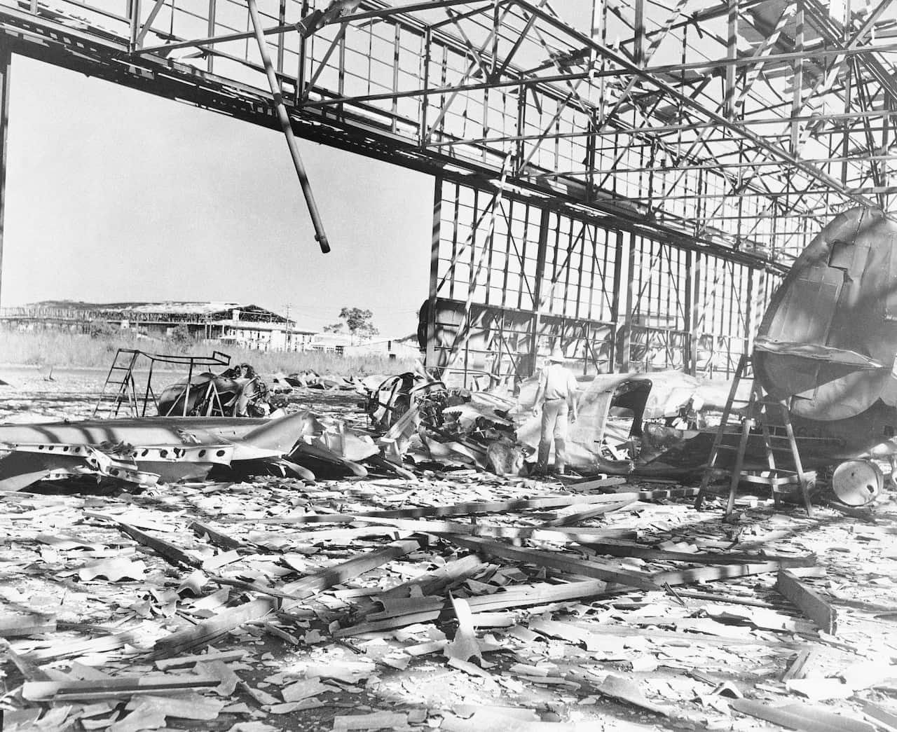 Japanese bombers which raided Port Darwin, Australia reportedly left this wreckage of a Hudson bomber strewn under the steel skeleton of an R.A.F. hangar, June 19, 1942.  In the left foreground is the wreckage of another bombed hangar. (AP Photo)