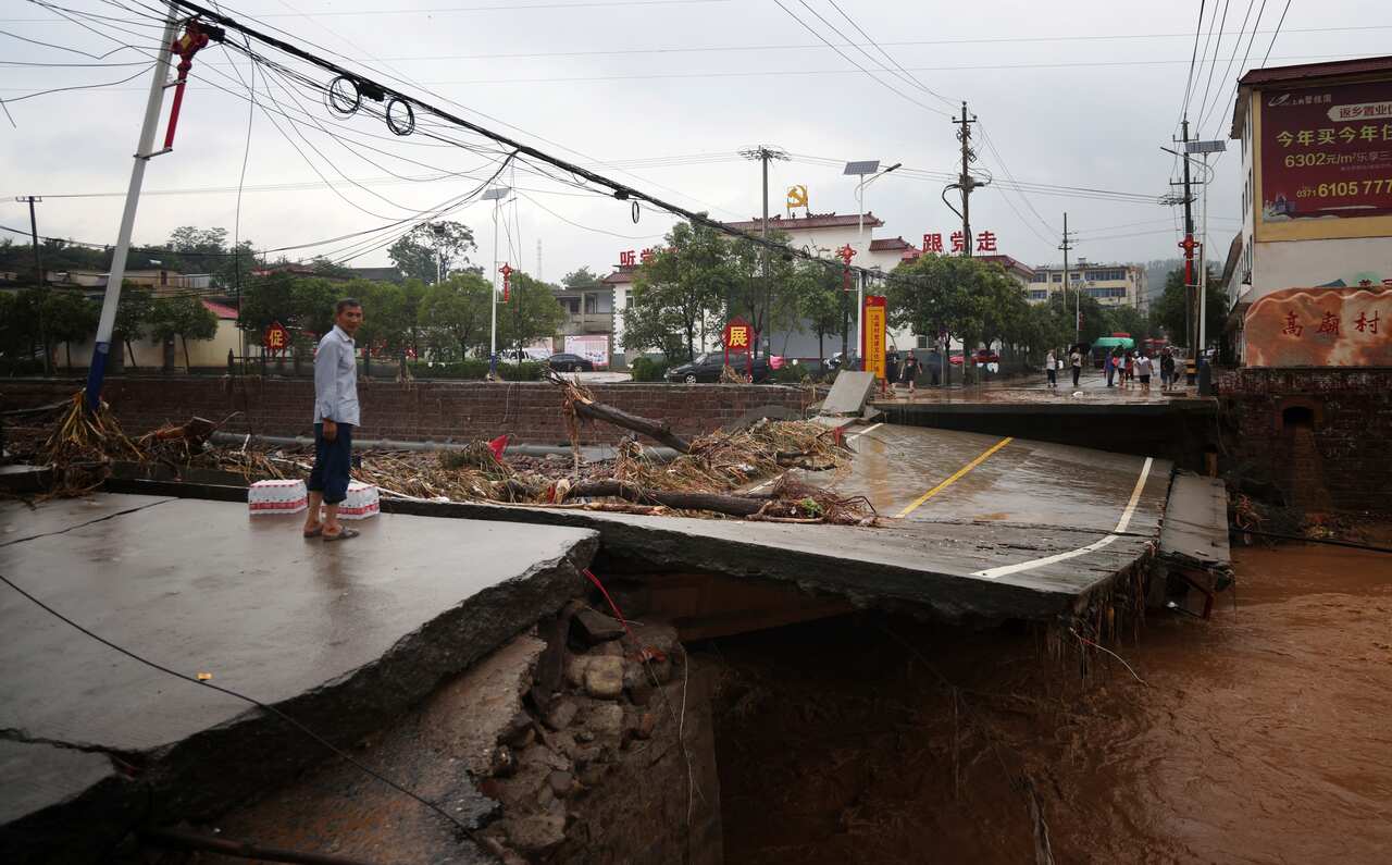 Damaged cars, bridges and roads are seen after a torrential rainfall in Gongyi City in central China's Henan Province, on 21 July, 2021.  