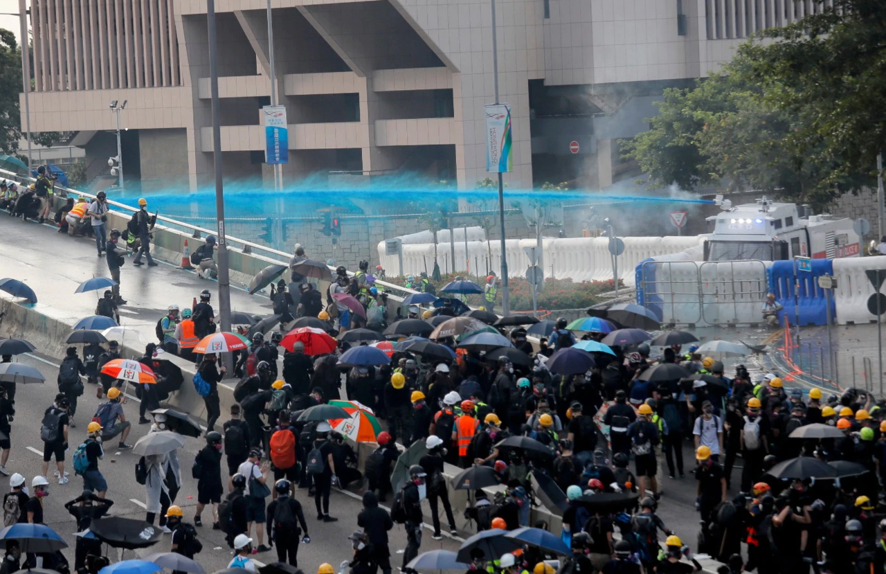 Anti-government protesters are sprayed with a water cannon during a demonstration near Central Government Complex in Hong Kong, Sunday, Sept. 15, 2019.