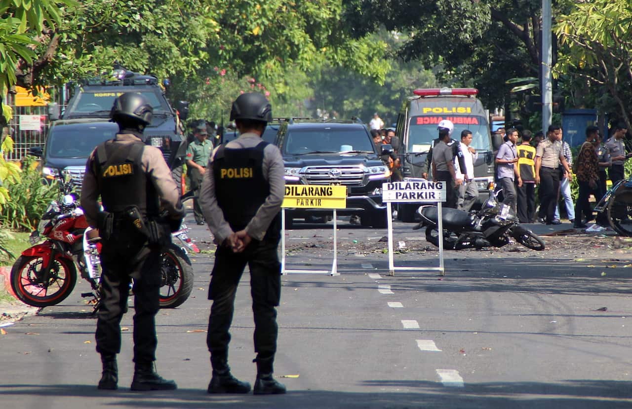 Indonesian bomb squad police officers inspect a blast site in front of a church in Surabaya, East Java, Indonesia, 13 May 2018.