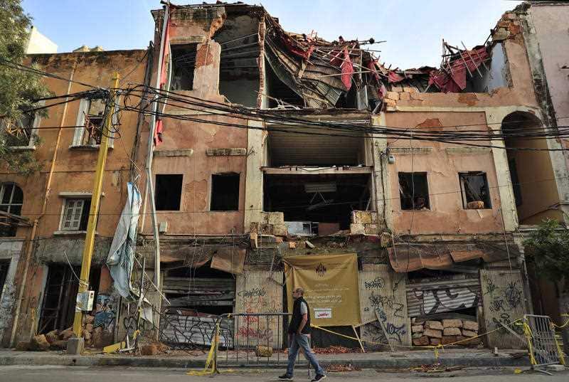 A man passes by a historical building that was damaged by the August 2020 massive explosion at th seaport, in Beirut, Lebanon, 2 February, 2021.
