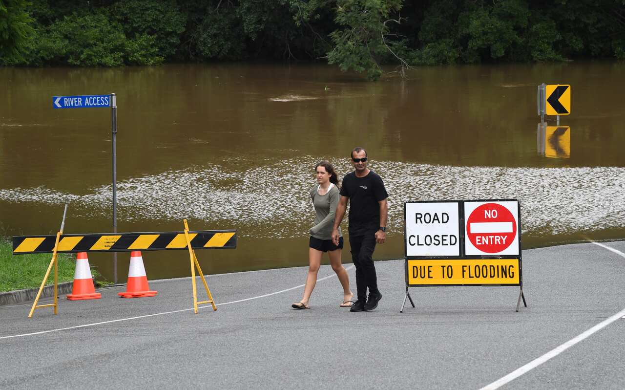 People are seen watching the flood waters from the Mary River in the town of Gympie on 9 January.