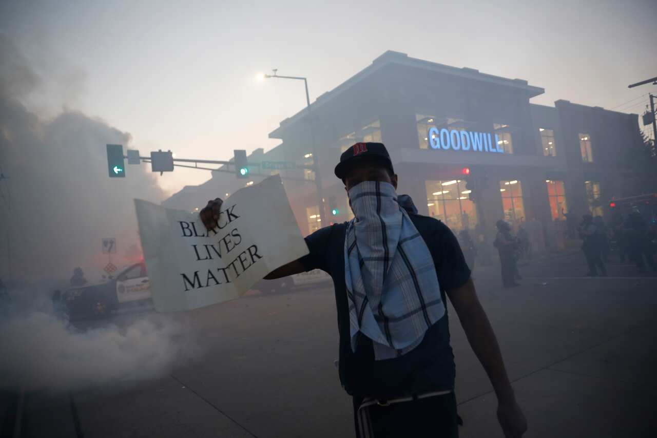 A demonstrator displays a "Black Lives Matter" sign Thursday, May 28, 2020, in St. Paul, Minn. Protests over the death of George Floyd, a black man who died in police custody, broke out in Minneapolis for a third straight night. (AP Photo/John Minchillo)