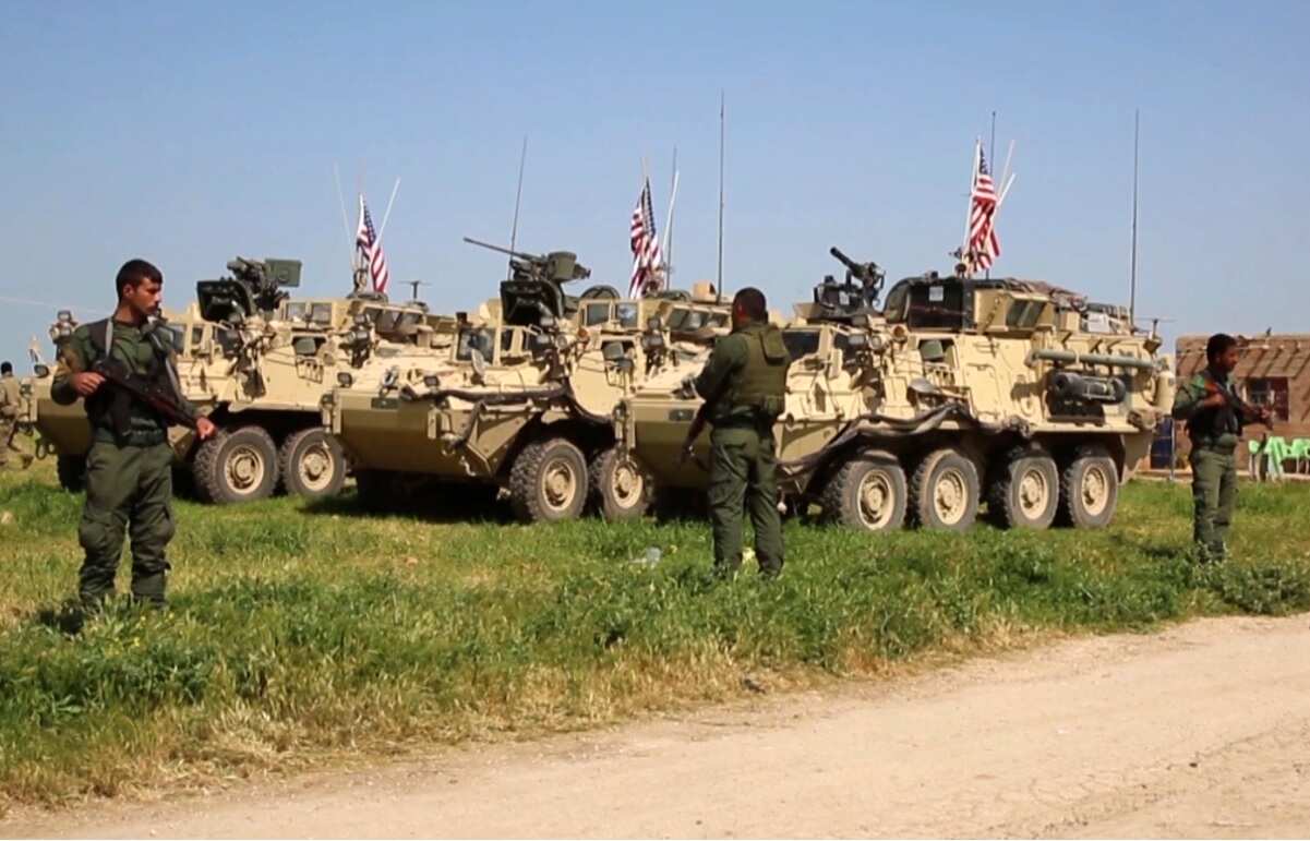 This Saturday, April. 29, 2017 still taken from video, shows Kurdish fighters of the People's Protection Units (YPG) standing guard as US forces in Syria