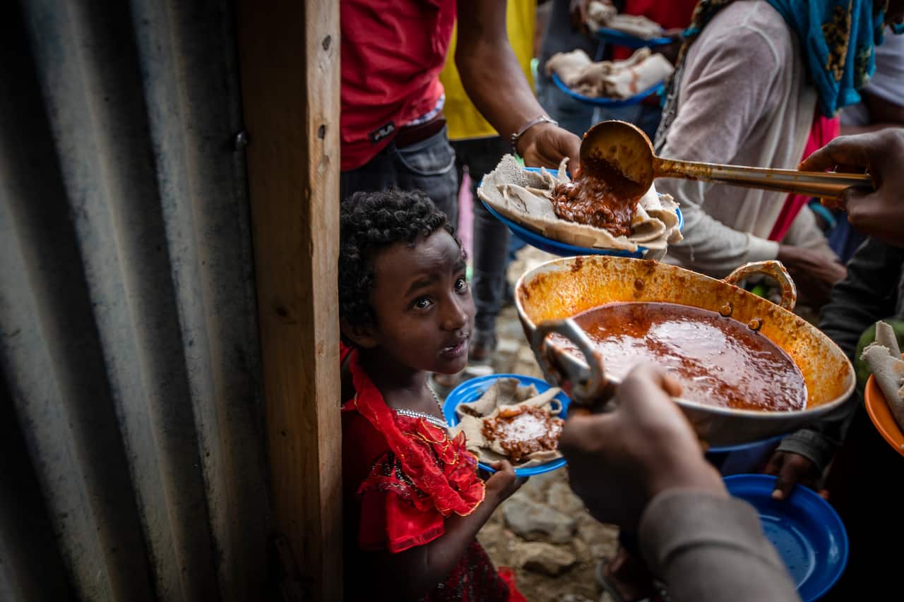 People receive food donated by local residents at a reception centre for the internally displaced in Mekele, in the Tigray region of northern Ethiopia