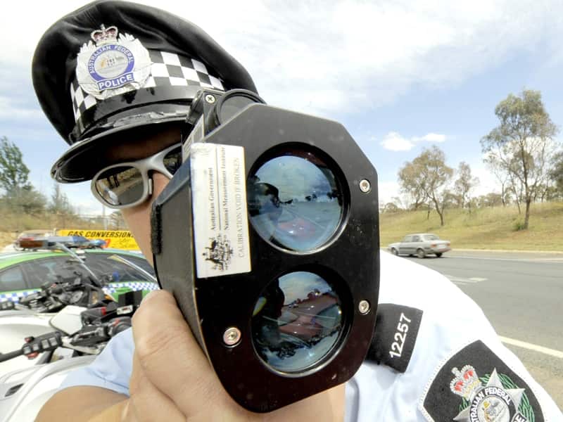 A police officer monitors traffic with radar
