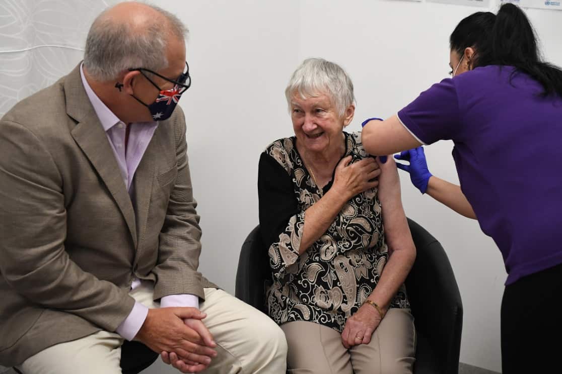 Prime Minister Scott Morrison joins Jane Malysiak (right) as she receives the first COVID-19 vaccine in Australia