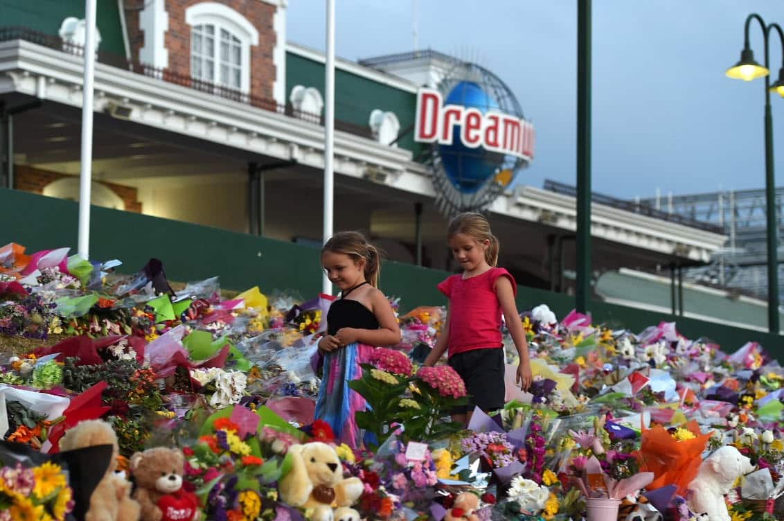 Young girls walk through a floral tribute outside the Dreamworld Theme Park on the Gold Coast, Friday, Oct. 28, 2016 (AAP)