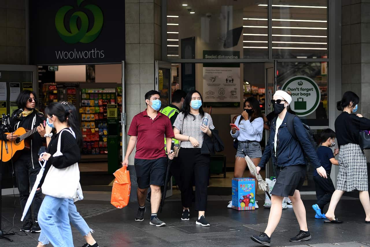 People wear masks as they walk past Woolworths in Sydney's CBD on 2 January, 2021.