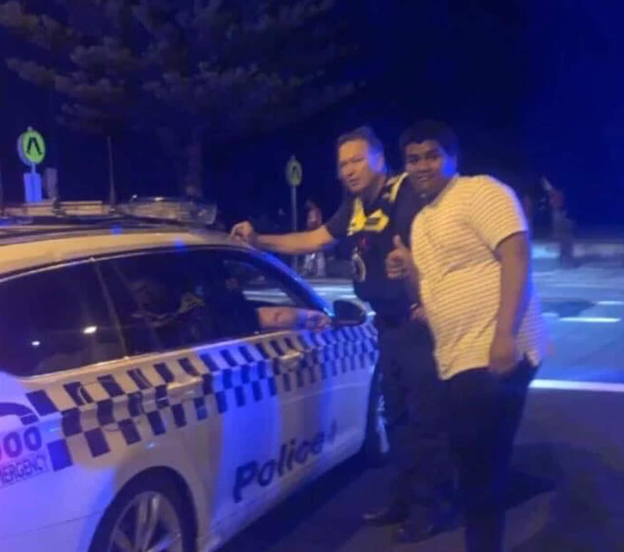 Solomone Taufeulungaki posing with a police officer.