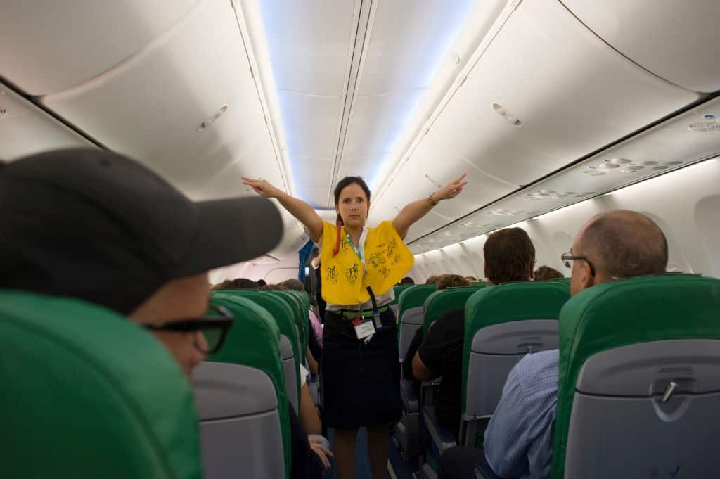 A flight attendant gives a safety demonstration