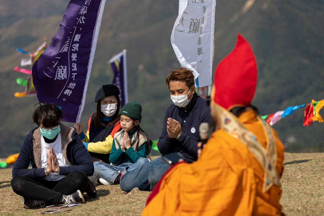 Worshippers and Ngawang Kunga Tenzin Gyatso Rinpoche pray during a Buddha Sunning Festival in Tai Mo Shan, Hong Kong, China.
