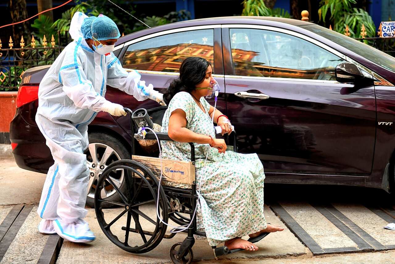 A COVID-19 patient on a wheelchair gets admitted at Kolkata Medical College Hospital in India.