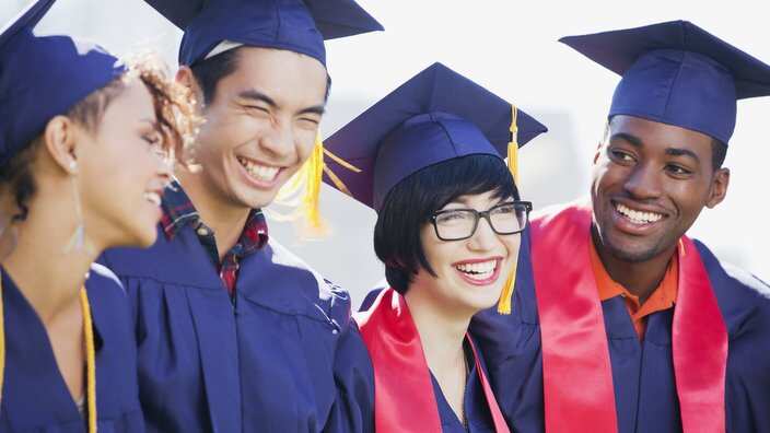 Smiling graduates standing together