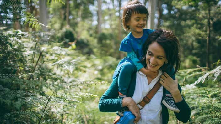 Mother hiking with her child in forest, Australia